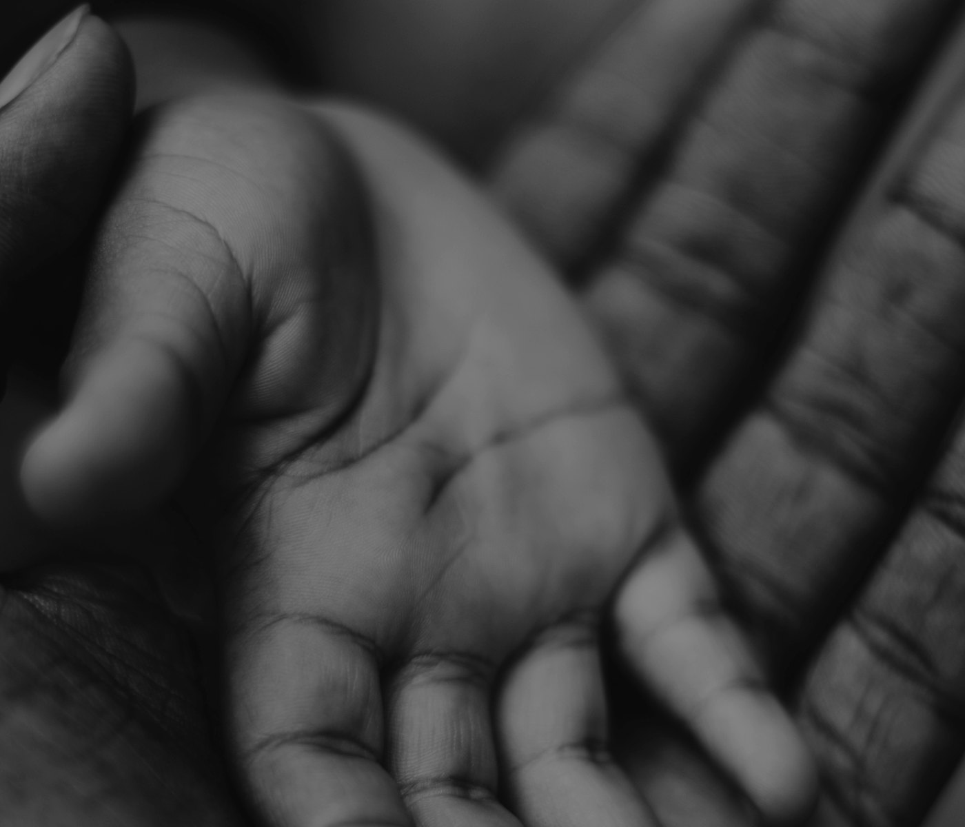 An older hand resting in a younger one